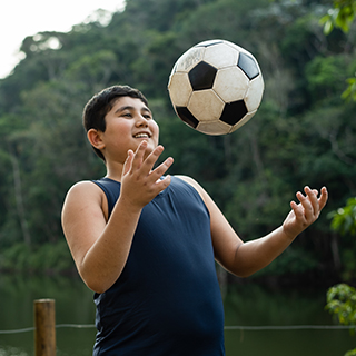 Young boy playing with a soccer ball.