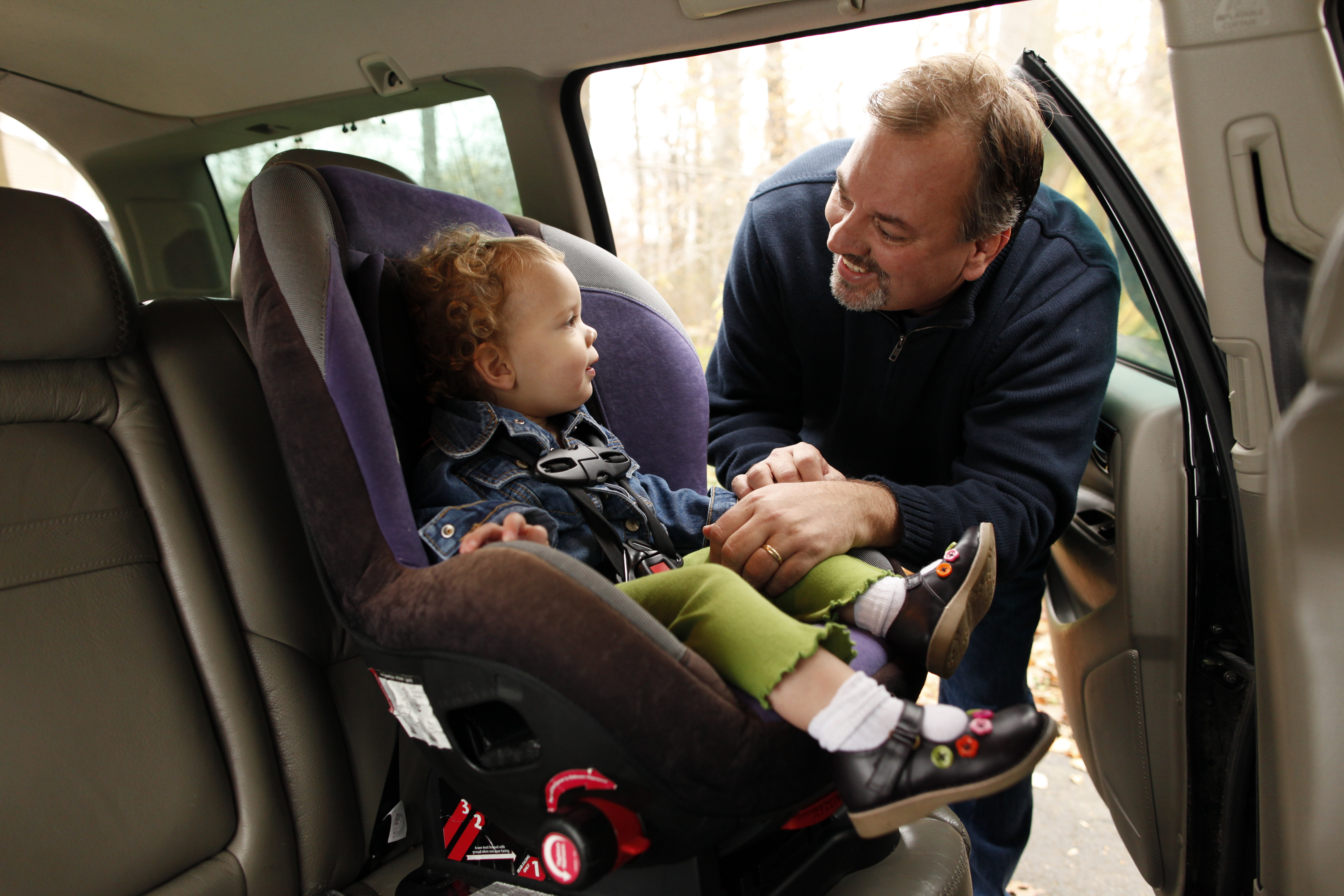 White father latches child's safety car seat